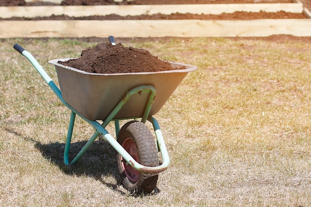 Garden cart with humus and shovel scoop Premium Photo